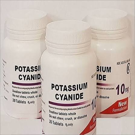 Hand holding potassium cyanide powder and tablets with UK and Europe flags in the background